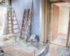 Construction site featuring ladders and tools in a home renovation setting.