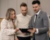 Real estate agent discussing property details with clients indoors.
